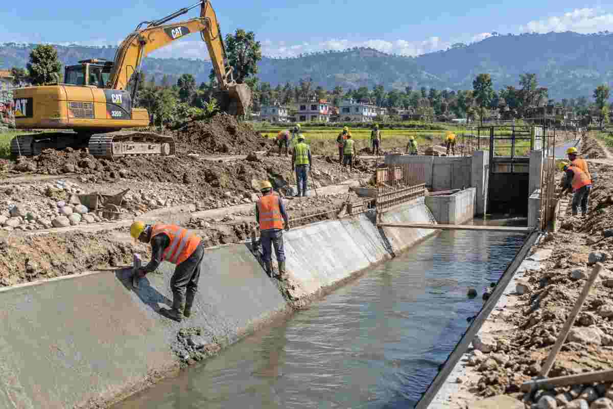 Active irrigation canal construction with workers and heavy equipment